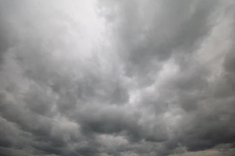 Dark storm clouds gather overhead, hinting at imminent rain and a change in.. Stock Photos