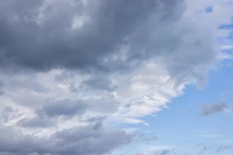 Dark storm clouds gathering against blue sky Foto stock