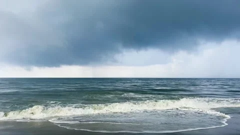 Dark storm clouds gathering over calm sea waves on tropical beach Stock Footage 346278155