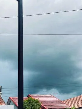 Dark Storm Clouds Gathering Over Residential Rooftops and Utility Pole Fotos Stock