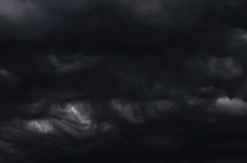 Dark storm clouds gathering in sky creating dramatic scene Stock Photos