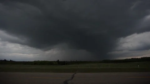 Dark storm clouds loom on the horizon behind a rural road Stock Footage 90830710