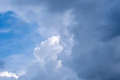 Dark Storm Clouds Mixing With Bright White Clouds Under a Vibrant Blue Sky 写真素材