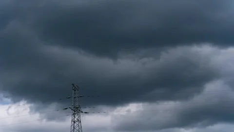 Dark storm clouds moving over a high voltage electricity transmission tower Video stock 342331777