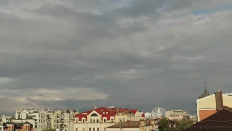 Dark storm clouds over city rooftops. Sunset in a European city. View from a Stock Footage 323437545
