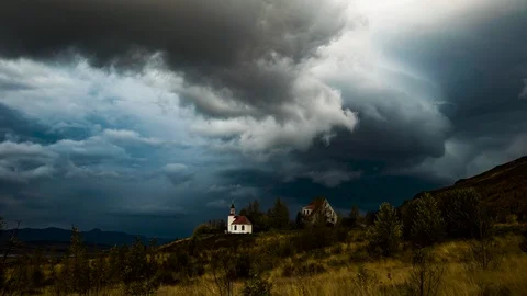 Dark storm clouds over Icelandic rural church cinematic time lapse Video stock 118095712