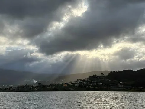 Dark storm clouds over a lake with a cloudy sky Stock Photos