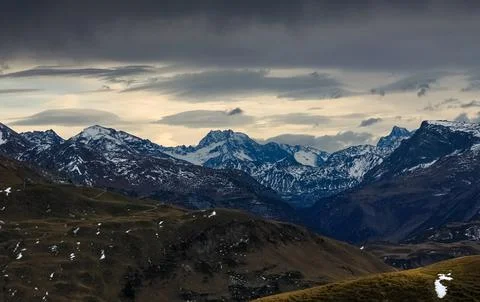 Dark storm clouds over snow spotted mountains. Allgau, Alps, Germany. Stock Photos