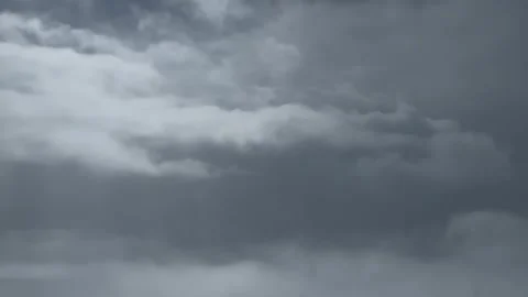 Dark storm clouds rolling across a grey sky, creating a dramatic weather scene Stock Footage 336839892