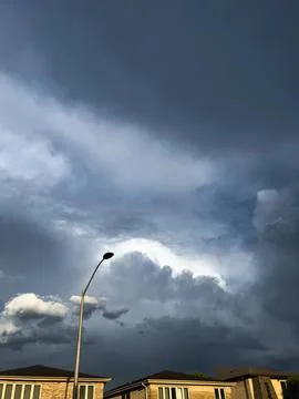 Dark storm clouds in the sky over city buildings Stock Photos