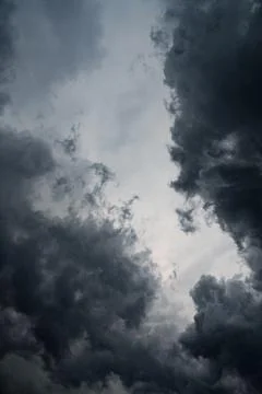 Dark storm clouds. Soft evening light breaks through the clouds, creating. Stock Photos