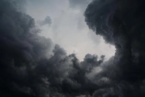 Dark storm clouds. Soft evening light breaks through the clouds, creating. Stock Photos