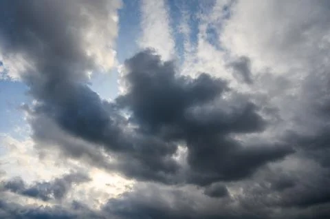 Dark Storm Clouds with Sun Rays Piercing Through, Dramatic Weather Scene Stock Photos