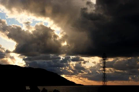 Dark storm clouds at sunset, dark storm clouds with sunrays Stock Photos