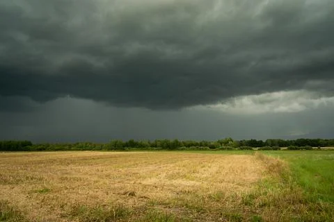 A dark stormy cloud over the fields Stock Photos
