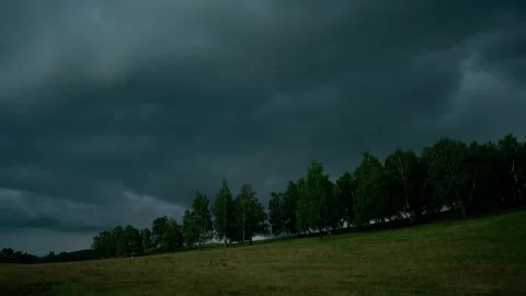 Dark stormy clouds flying over forest on a hillside Видео 246788284