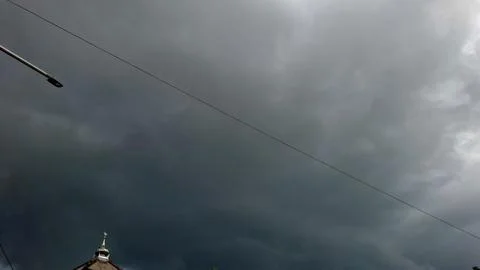 Dark Stormy Clouds Gathering in Sky Over Building Top Fotos Stock