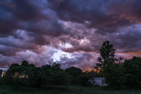 Dark stormy rain clouds flow over the sky in the evening. Stock Photos