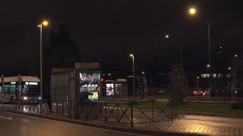 A dark street with a bus stop and a few street lights Vídeos de archivo 328959697