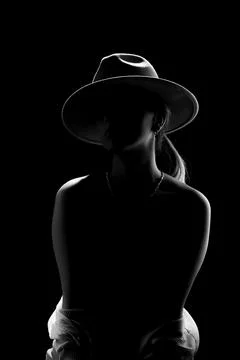 Dark studio portrait of young elegant sexy woman with a white hat and white.. Stock Photos