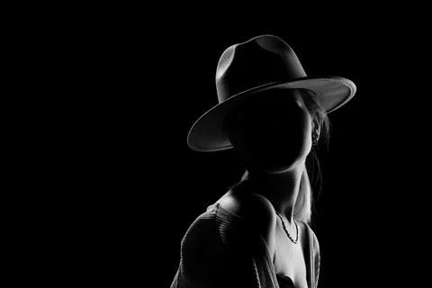 Dark studio portrait of young elegant sexy woman with a white hat and white.. Stock Photos
