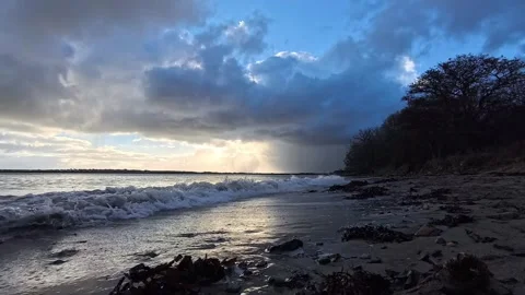 Dark sunset beach with waves sunlit and sparkling in last evening light Stock Footage 325660329
