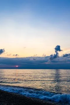 Dark sunset sky with clouds and pink setting sun Stock Photos