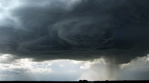 Dark supercell cloud unloading rain or hail over a prairie landscape Stock Footage 59513716