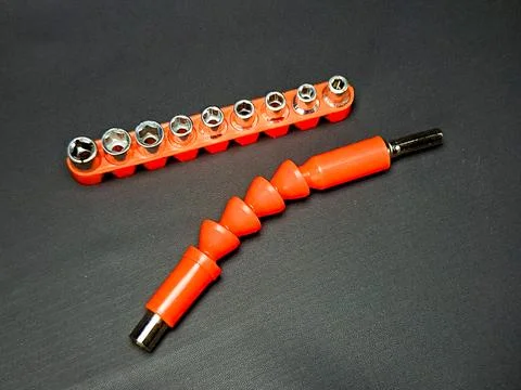 On a dark surface lies orange socket set and flexible shaft extension repre.. Stock Photos