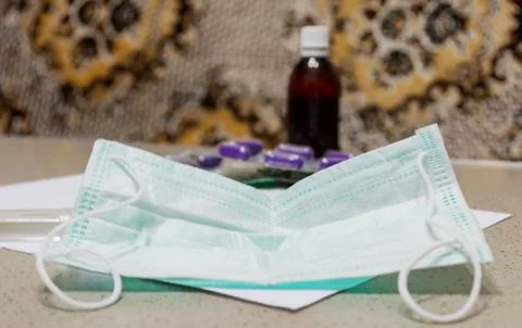 On a dark table are a protective mask against viruses with the inscription 20 Stock Photos