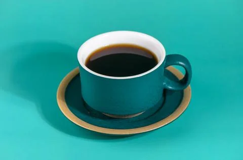 Dark Teal Ceramic Coffee Cup with Black Coffee on Turquoise Фото