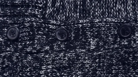 The dark texture of a knitted sweater. Buttons close up. Stock Footage 111564954