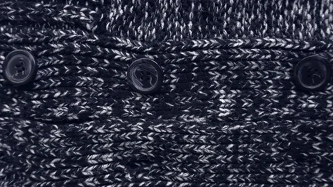 The dark texture of a knitted sweater. Buttons close up. Vídeo Stock 111564965