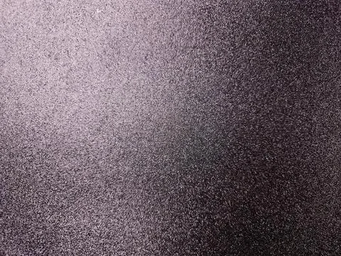 Dark textured metallic surface with subtle grain pattern Stock Photos