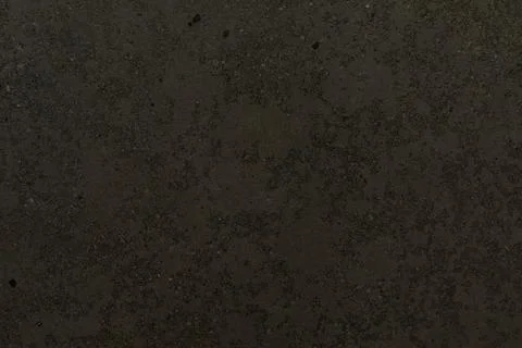 Dark textured surface featuring subtle patterns and variations in tone suitable Stock Photos