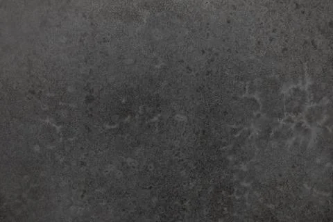 Dark textured surface with subtle patterns highlighting natural variations and Foto stock