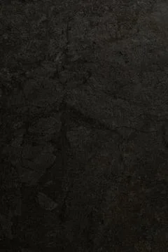 Dark textured surface with subtle patterns showing age and depth during low Stock Photos