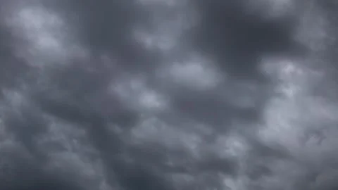 Dark thick gray clouds slowly float across the sky closing Stock Footage 241180632
