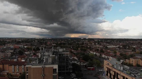 Dark thunder storm clouds covering half the sky rolling over city of Stock Footage 93691618