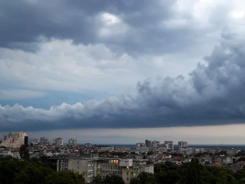 Dark thundercloud in the form of an arc is approaching city Stock Photos