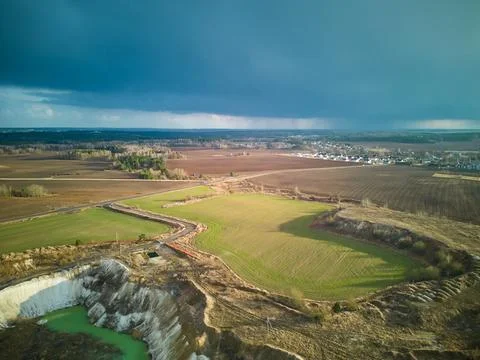 A dark thundercloud is moving over a rural field. A cloud with a clearly visi Stock Photos