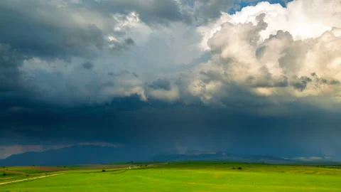 Dark thunderclouds over lighted spring fields Stock Footage 108095125