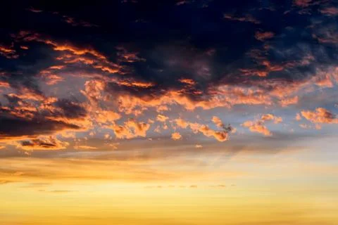 Dark thunderclouds with red orange reflections of the sunset. Stock Photos