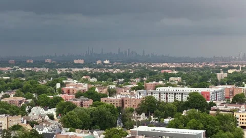 Dark thunderstorm clouds loom over Orange, New Jersey brick apartment rooftops Stock Footage 341842729