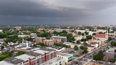Dark thunderstorm clouds loom over historic Orange, New Jersey rooftops, with a Stock Footage 342106208