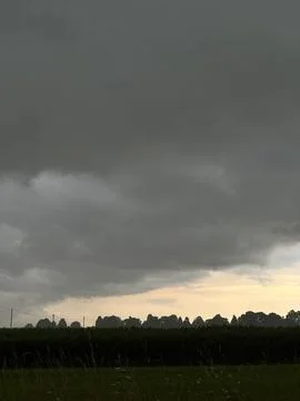 Dark Thunderstorm Clouds Over Rural Fields at Sunset Stock Photos