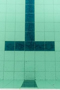 Dark tiles of a pool in the shape of a T Stock Photos