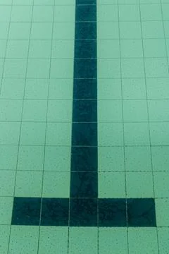 Dark tiles of a pool in the shape of a T Stock Photos