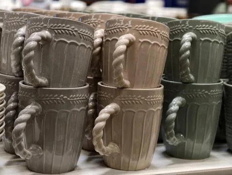 Dark tone ceramic cups displayed on supermarket shelves forming a simple un.. Stock Photos