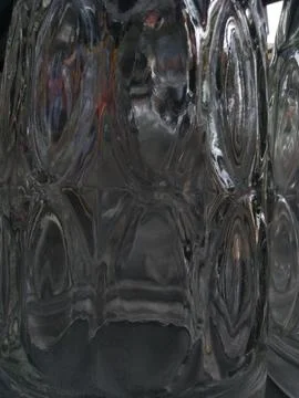 A dark toned abstract image of thick glass with a repeating pattern Fotos Stock